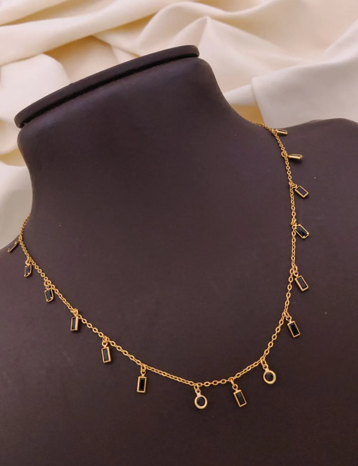Minimalist gold charm necklace with rectangular and circular accents